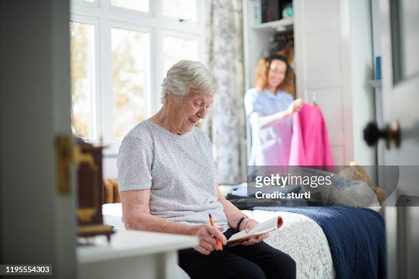 betreutes wohnen senior - nurse helping old woman at home stock-fotos und bilder