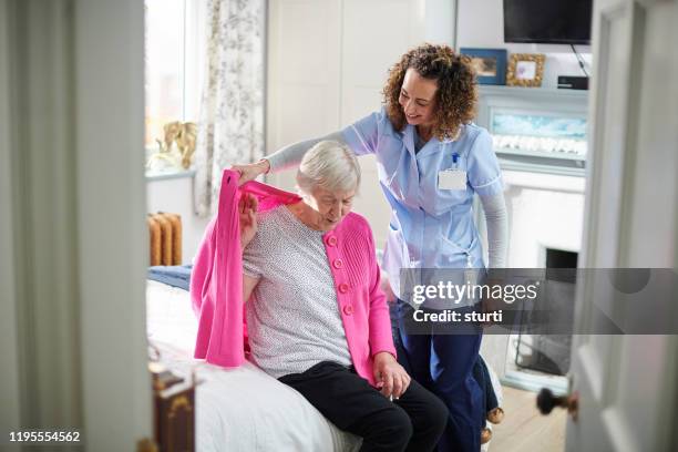 home carer visit - senior getting dressed stock pictures, royalty-free photos & images