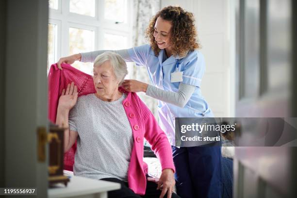 home carer visit - nurse helping old woman at home stock pictures, royalty-free photos & images