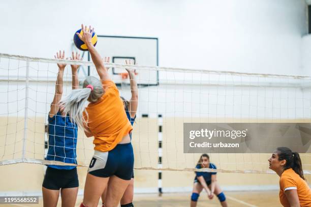 vrouwelijke volleybal speler die de bal stekken - volleybal stockfoto's en -beelden