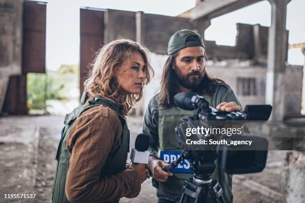 man and woman war journalists in war zone - conflict zone stock pictures, royalty-free photos & images