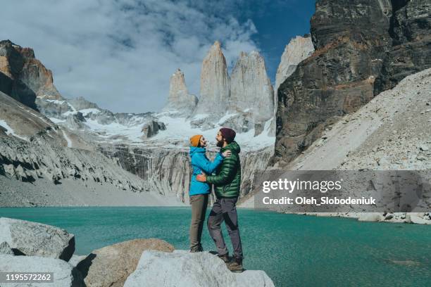 paar dat zich op de achtergrond van torres del paine nationaal park bevindt - cuernos del paine stockfoto's en -beelden