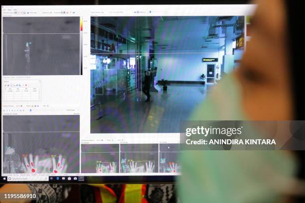 Indonesian health officers screen passengers with a thermal scanner at the Depati Amir airport in Pangkal Pinang on Bangka Belitung island on January...