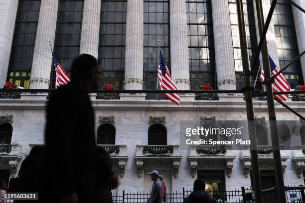 People walk by the New York Stock Exchange during the beginning of the Christmas holiday week on December 23, 2019 in New York City. Following news...