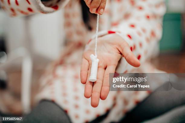 a woman holding one tampon - absorb fotografías e imágenes de stock