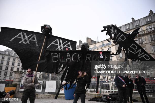 Protesters hold puppets shaped as crows and reading BlackRock, a US global investment management corporation Axa and BNP for the French banking group...