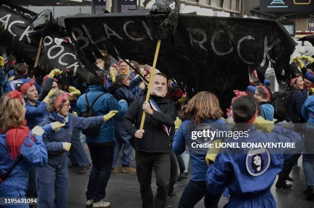 Protester holds a puppet shaped as crow and reading BlackRock, a US global investment management corporation among feminist activists performing the...