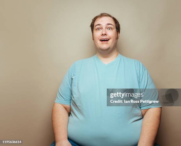 overweight man in blue shirt making faces - human build ストックフォトと画像