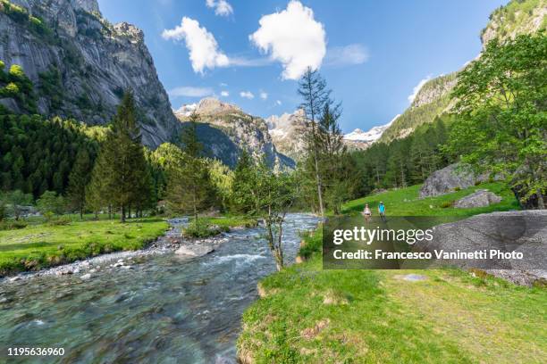 couple hiking in val di mello, sondrio province, italy. - valley foto e immagini stock