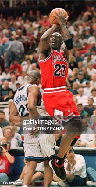 Chicago Bulls guard Michael Jordan takes to the air past Orlando Magic guard Nick Anderson for two points during the second period of game four of...