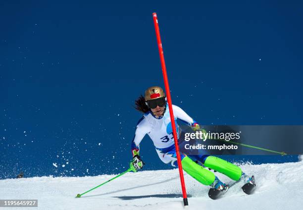 adult female alpine skier racing slalom - slalom skiing stock-fotos und bilder