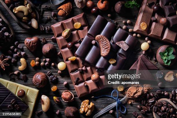 low-key variatie van chocolade en bombones met cacaopoeder en gedroogde vruchten in ouderwetse stijl - suikervrij stockfoto's en -beelden