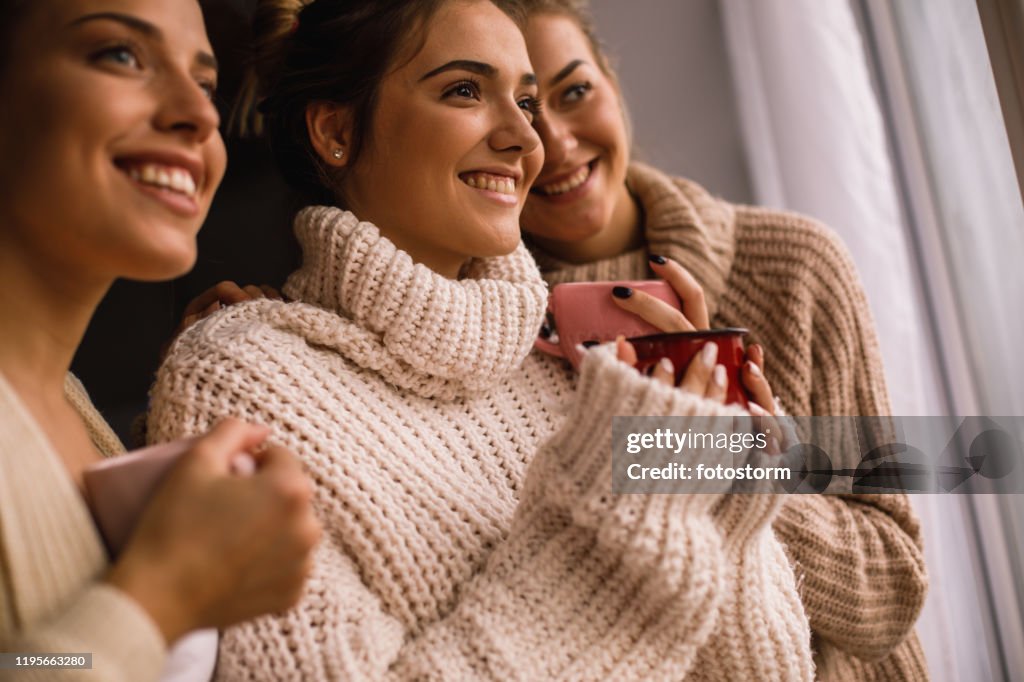 Low-Winkel-Ansicht von drei glücklichen Frauen, die durch das Fenster schauen