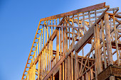 New construction home residential construction home framing against a blue sky