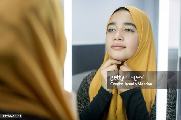 muslim girl putting hijab in the mirror - beautiful arabian girls stock-fotos und bilder
