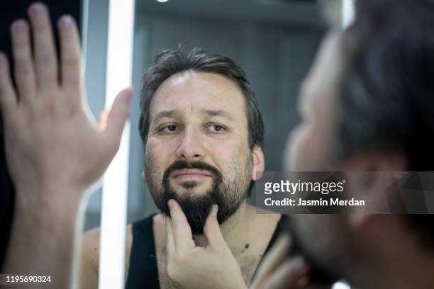 bearded man with mirror - cheveux secs photos et images de collection