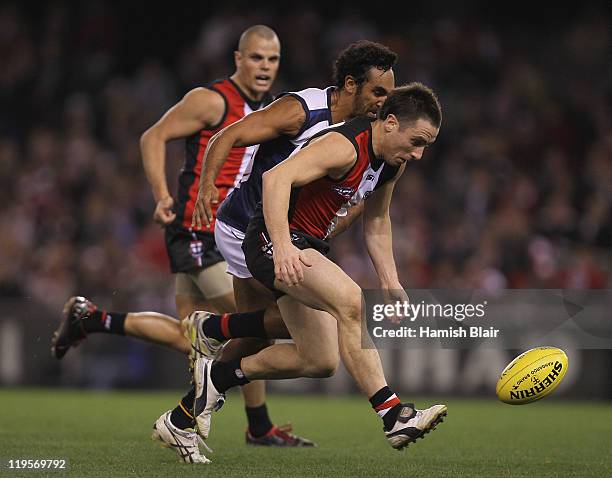 Stephen Milne of the Saints is pressured by Richard Tambling of the Crows during the round 18 AFL match between the St Kilda Saints and the Adelaide...