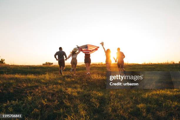 spreading american flag - fourth of july stock pictures, royalty-free photos & images