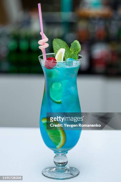 blue lagoon cocktail with a slice of lime and mint - blue curacao stock pictures, royalty-free photos & images