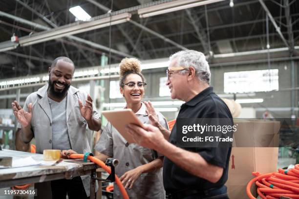 team feiert in einer fabrik - diversity people industry stock-fotos und bilder