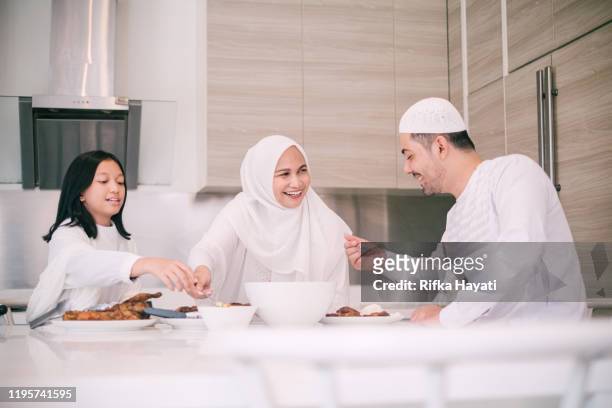 schöne familie essen während hari raya aidilfitri - hari raya celebration stock-fotos und bilder