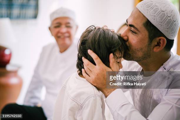 bella famiglia che chiede perdono su hari raya aidilfitri / eid-ul-fitr - muslim family foto e immagini stock