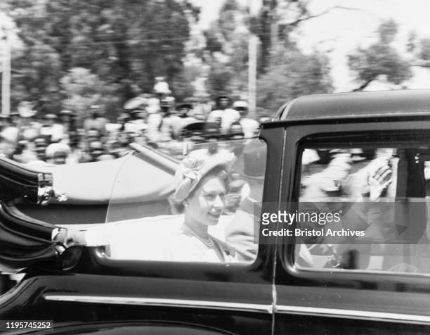 An open topped car speeds past the camera carrying Princess Elizabeth and the Duke of Edinburgh to Nairobi's City Hall, during their Commonwealth...