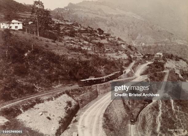 India, View of the 'Gayabari Reverse' on the Darjeeling Hill Railway, showing two trains, one busy passenger train and one with covered goods wagons....