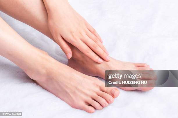 perfect female feet. hand touching - womens pretty feet stock pictures, royalty-free photos & images