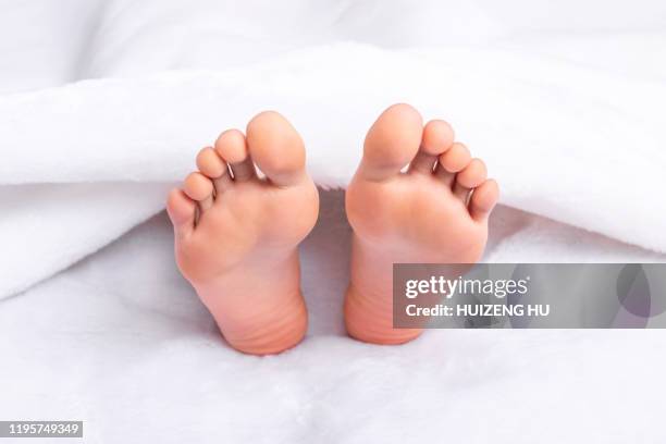 beautiful feet of a young woman lying in bed. woman's bare feet - womans bare feet fotografías e imágenes de stock