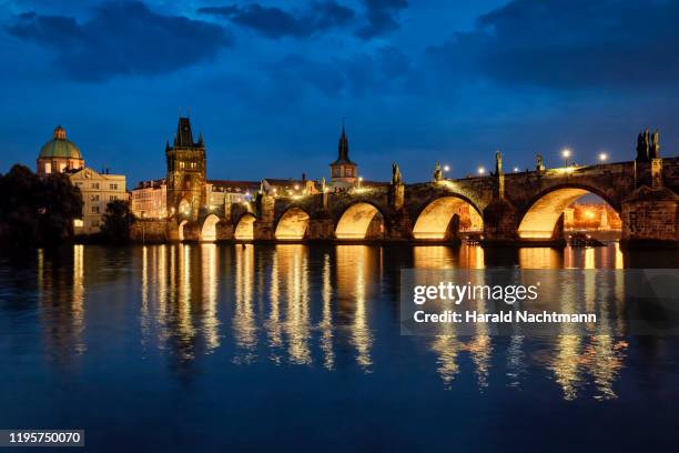 charles bridge with bridge tower and vltava river at night, prague, bohemia, czech republic - karlsbrücke stock-fotos und bilder