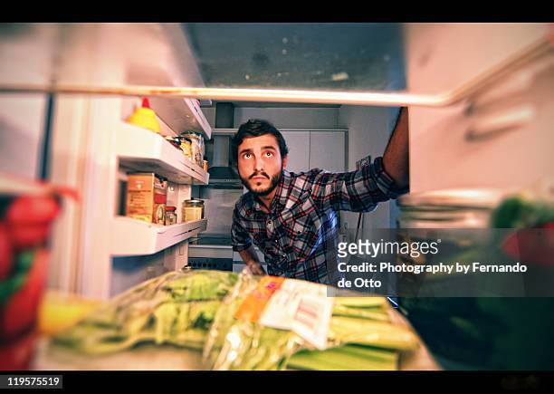 man looking in refrigerator - refrigerator stock-fotos und bilder