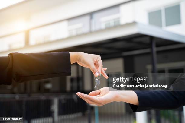 home buyers are taking home keys from sellers. sell your house, rent house and buy ideas. - arrendatario fotografías e imágenes de stock