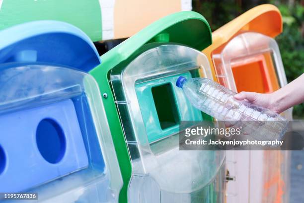 close up hand throwing empty plastic bottle into the trash - office recycling stock pictures, royalty-free photos & images