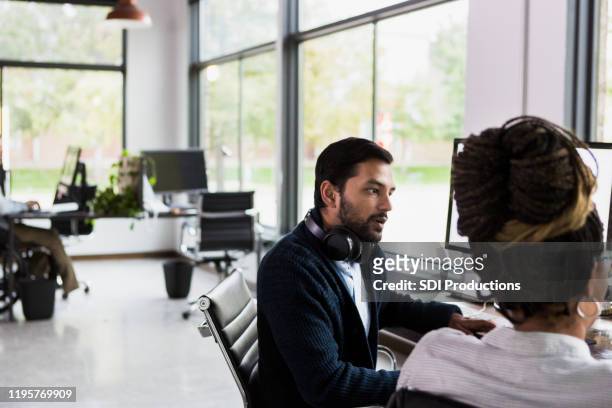 two co-workers discuss the quarterly numbers for their department - quarterly stock pictures, royalty-free photos & images