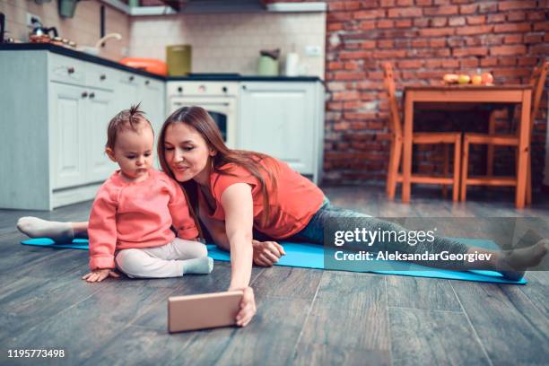 beautiful mother taking selfie with baby daughter while exercising - girl yoga stock pictures, royalty-free photos & images