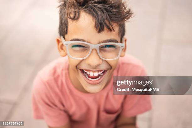 chico feliz riendo al aire libre - gafas fotografías e imágenes de stock