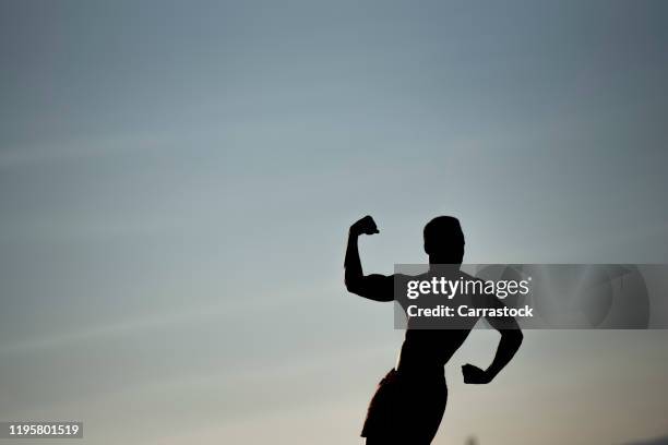 silhouette of one muscular african man - core strength stock pictures, royalty-free photos & images