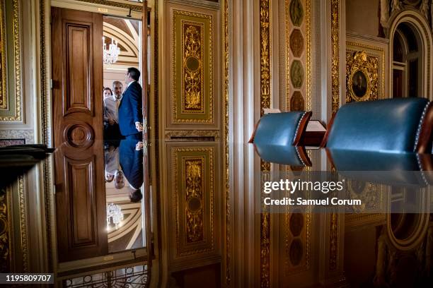 Representative John Ratcliffe holds open the door for Representative Jim Jordan as President Donald Trumps defense team leaves their meeting room to...