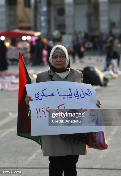 Woman holds a banner during a protest against the attacks and ceasefire violations of Libya's renegade Gen. Khalifa Haftar's troops, which has been...