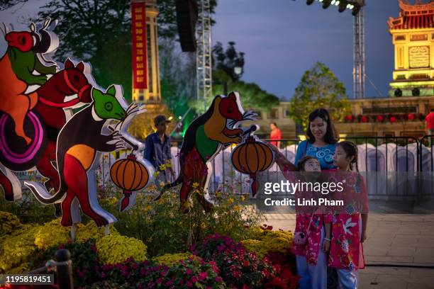 Family poses for photos in front of a display of rats in Vietnamese folk style to mark the Lunar New Year or Tet celebrations on January 24, 2020 in...