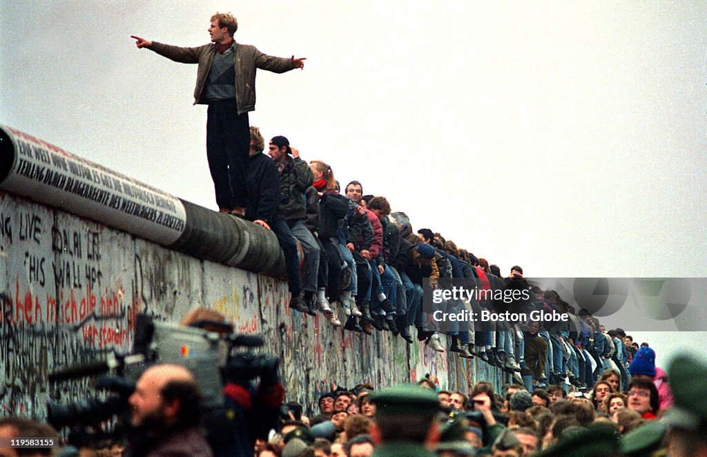 People Stand On The Berlin Wall