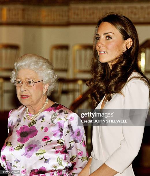 Britain's Queen Elizabeth II talks with Catherine, the Duchess of Cambridge as they view the dress she wore for her royal wedding to Britain's Prince...