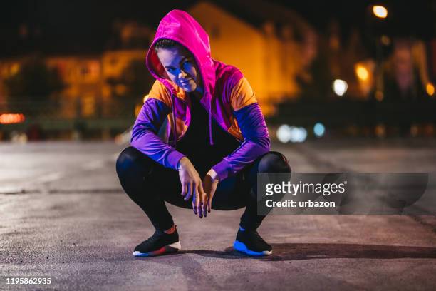woman in sport wear crouching - rapper stock pictures, royalty-free photos & images
