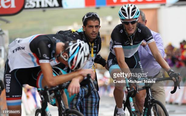 Andy Schleck of Luxemburg and Team Leopard-Trek crosses the finishing line alongside his exhausted brother Frank Schleck and claim the race leaders...