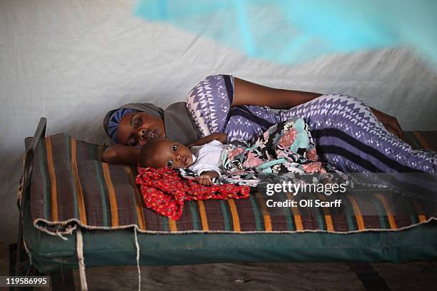 Malnourished refugee mother and child lay in a ward of the Medecins Sans Frontieres Hospital in the Dagahaley refugee camp which makes up part of the...