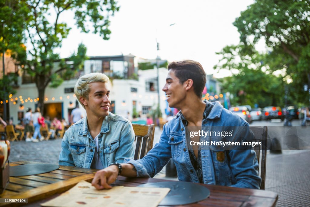 Young gay couple in a street restaurant