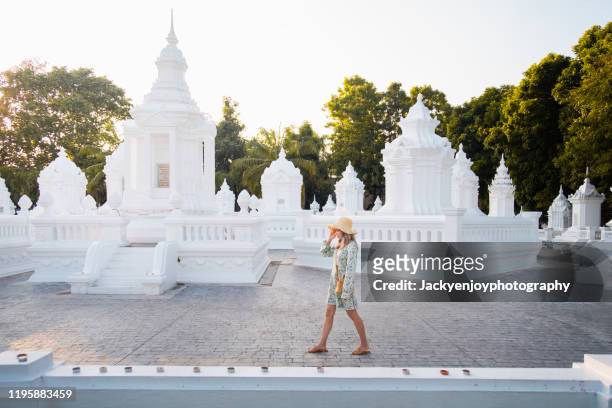 solo traveller woman walking inside the wat suandork temple, chiangmai - wat benchamabophit stock pictures, royalty-free photos & images