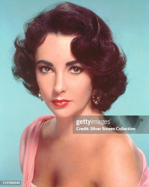 Elizabeth Taylor , British actress, posing with a bare shoulder in a studio portrait, against a pale blue background, circa 1955.