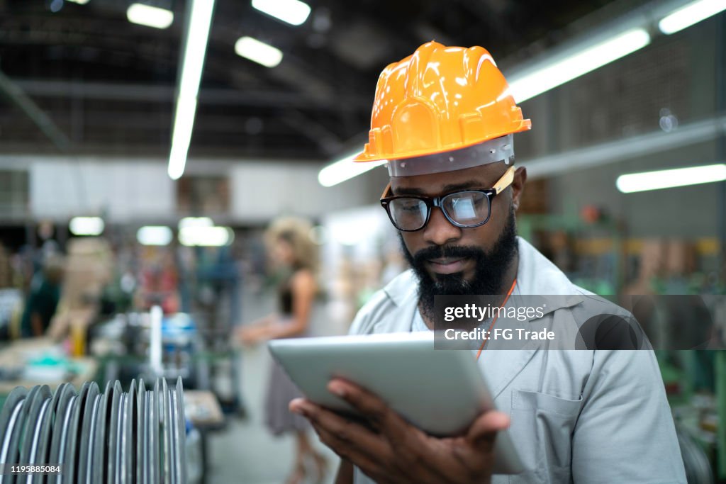 Ingeniero usando tabletas y trabajando en fábrica